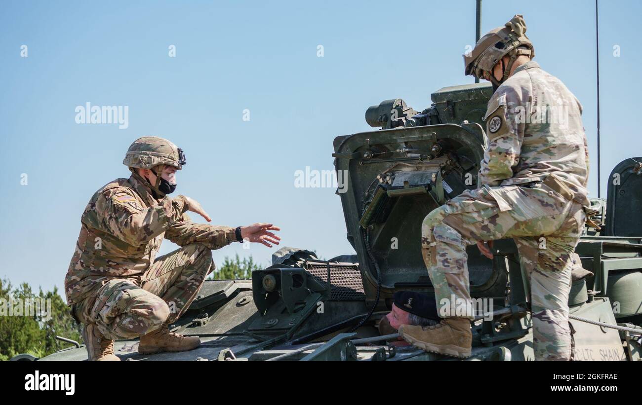 Sgt. Thomas Hill (left), Infantryman, Thunder Squadron, 3rd Cavalry Regiment, gives a tour of a Command Variant Stryker to British Army Maj. Alistair Biggs, Chief of Staff, 11th Signal Brigade, 3rd Stock Photo