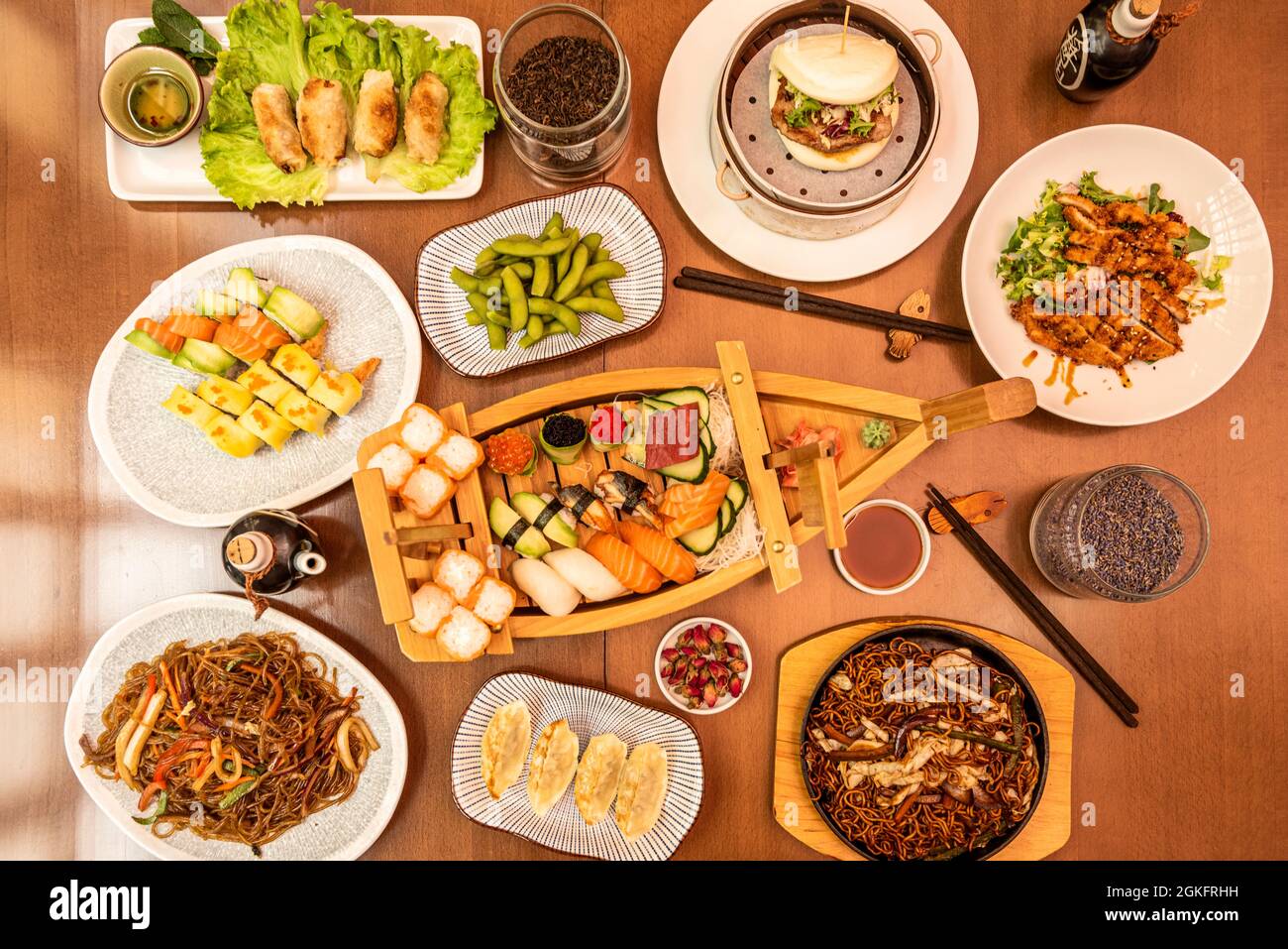 set of typical dishes Japanese dishes, sushi, uramaki, gyozas, edamame and chia on restaurant table. Stock Photo