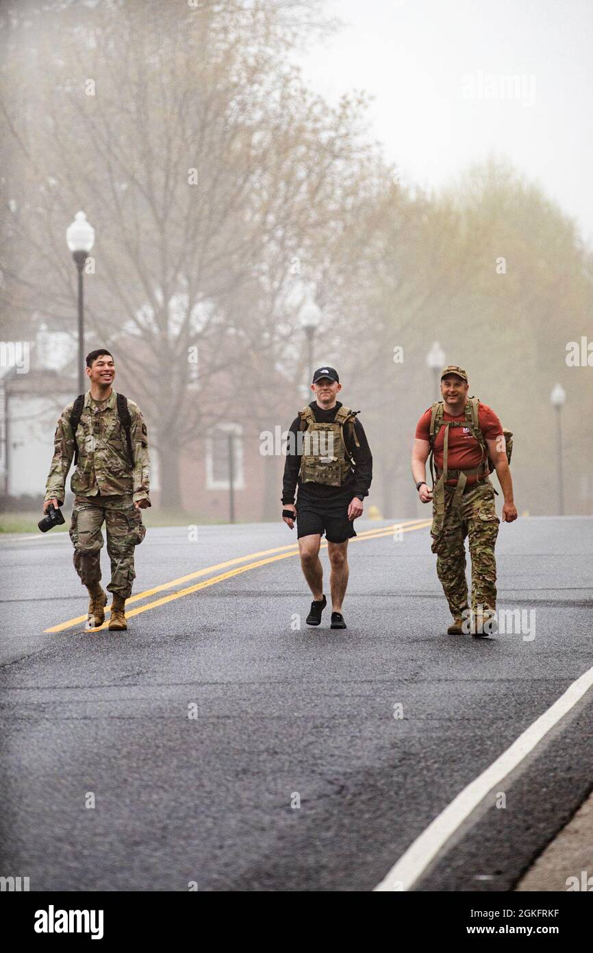 U.S. Army Capt. Phillip Lee, Staff Sgt. Brandon Franklin and Spc. Christopher Cameron, assigned to 55th Signal Company (Combat Camera) conduct the 26-mile Bataan Memorial Death March on Fort George G. Meade, Maryland, April 10, 2021. The Bataan Death March took place in April 1942, where American and Filipino prisoners of war were forced to walk 66 miles. Stock Photo