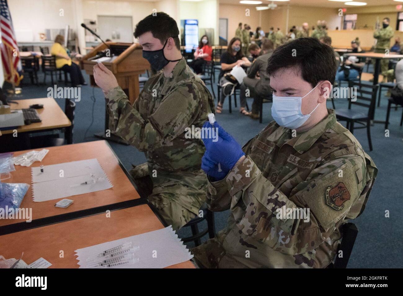 U.S. Air Force Staff Sgt. Ian Miller and Master Sgt. Matthew Stickley, aerospace medical technicians with the 167th Medical Group, currently assigned to the West Virginia National Guard’s Task Force Medical – East, prepare Pfizer COVID-19 vaccinations for military members and families in the 167th Airlift Wing dining facility, Martinsburg, West Virginia, Apr. 11, 2021.  The vaccine was offered to all military personnel and their dependents over 16-years-old. Stock Photo