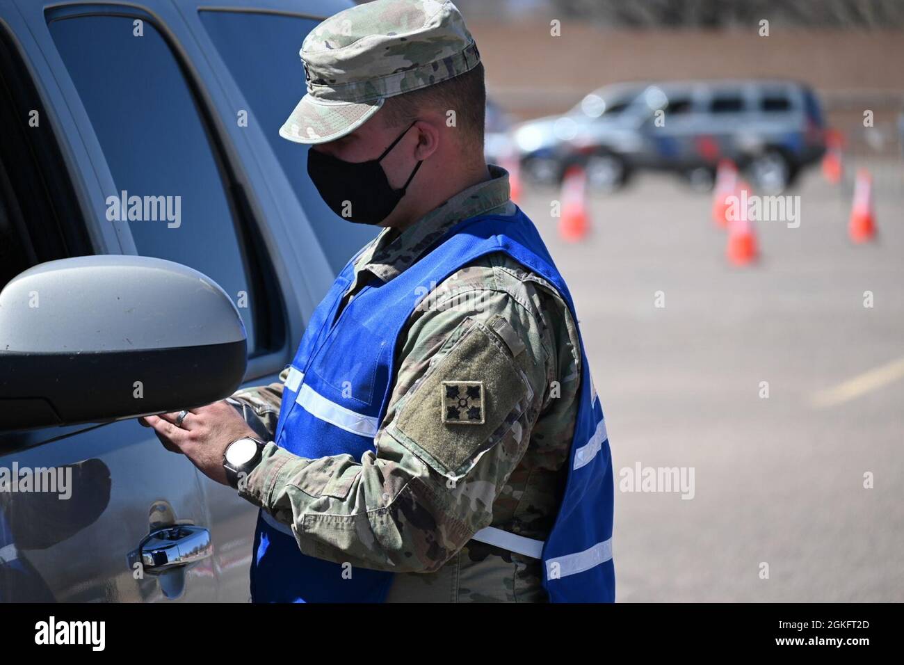 U.S. Army Pfc. James Holmes, a Clarksville, Tennessee, native and combat medic, assigned to the 1st Battalion, 12th Infantry Regiment, checks in a patient on the drive-up lanes at the Community Vaccination Site (CVS) in Pueblo, Colorado, April 11, 2021. The drive-up lanes enable community members to acquire their COVID vaccination without having to exit their vehicles. U.S. Northern Command, through U.S. Army North, remains committed to providing continued, flexible Department of Defense support to the Federal Emergency Management Agency as part of the whole-of-government response to COVID-19. Stock Photo