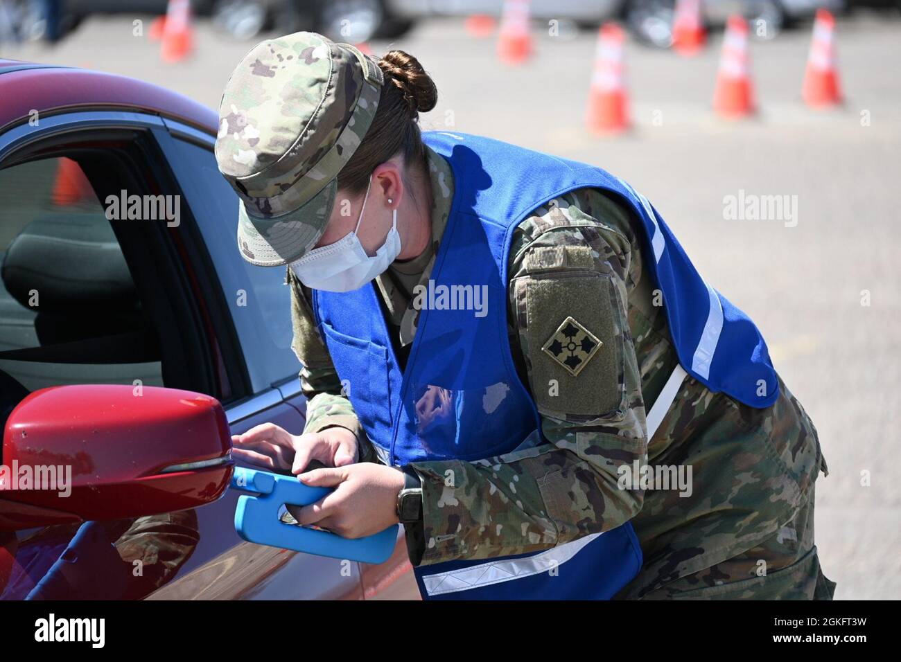 U.S. Army Spc. Bethany Parks, a Bloomfield, New Mexico, native and combat medic, assigned to the 1st Battalion, 12th Infantry Regiment, checks in a patient at the drive-up lanes at the Community Vaccination Site (CVS) in Pueblo, Colorado, April 11, 2021. The drive-up lanes enable community members to acquire their COVID vaccination without having to exit their vehicles. U.S. Northern Command, through U.S. Army North, remains committed to providing continued, flexible Department of Defense support to the Federal Emergency Management Agency as part of the whole-of-government response to COVID-19 Stock Photo