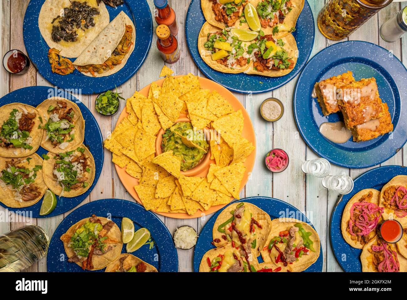 Set of popular Mexican gastronomy dishes. Tacos al pastor, corn nachos with guacamole, cochinita pibil tacos, corn cake, chicken tinga tacos. Stock Photo