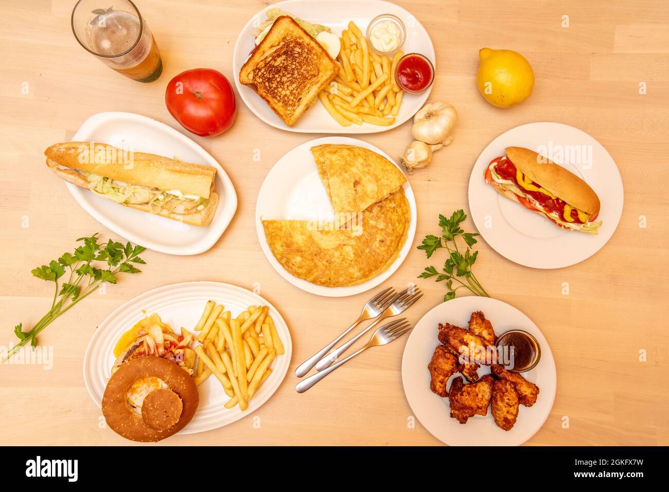 Dishes and snacks of a restaurant seen from the top. Chicken wings, puppy, burger, potato omelette, chicken sandwich. Stock Photo