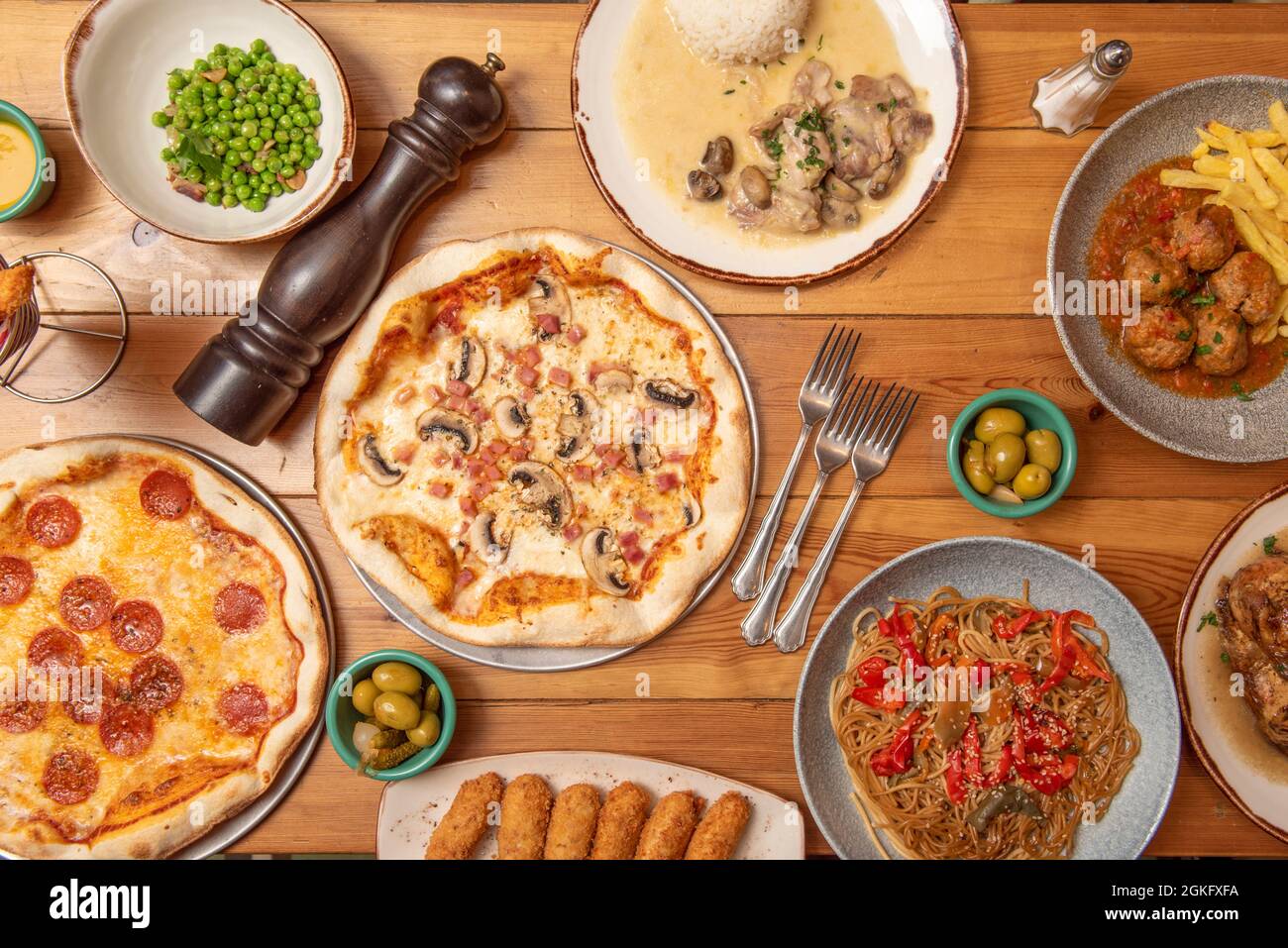 Set of pasta dishes and Spanish food on wooden table. Croquettes, peas with ham, beef meatloaf
