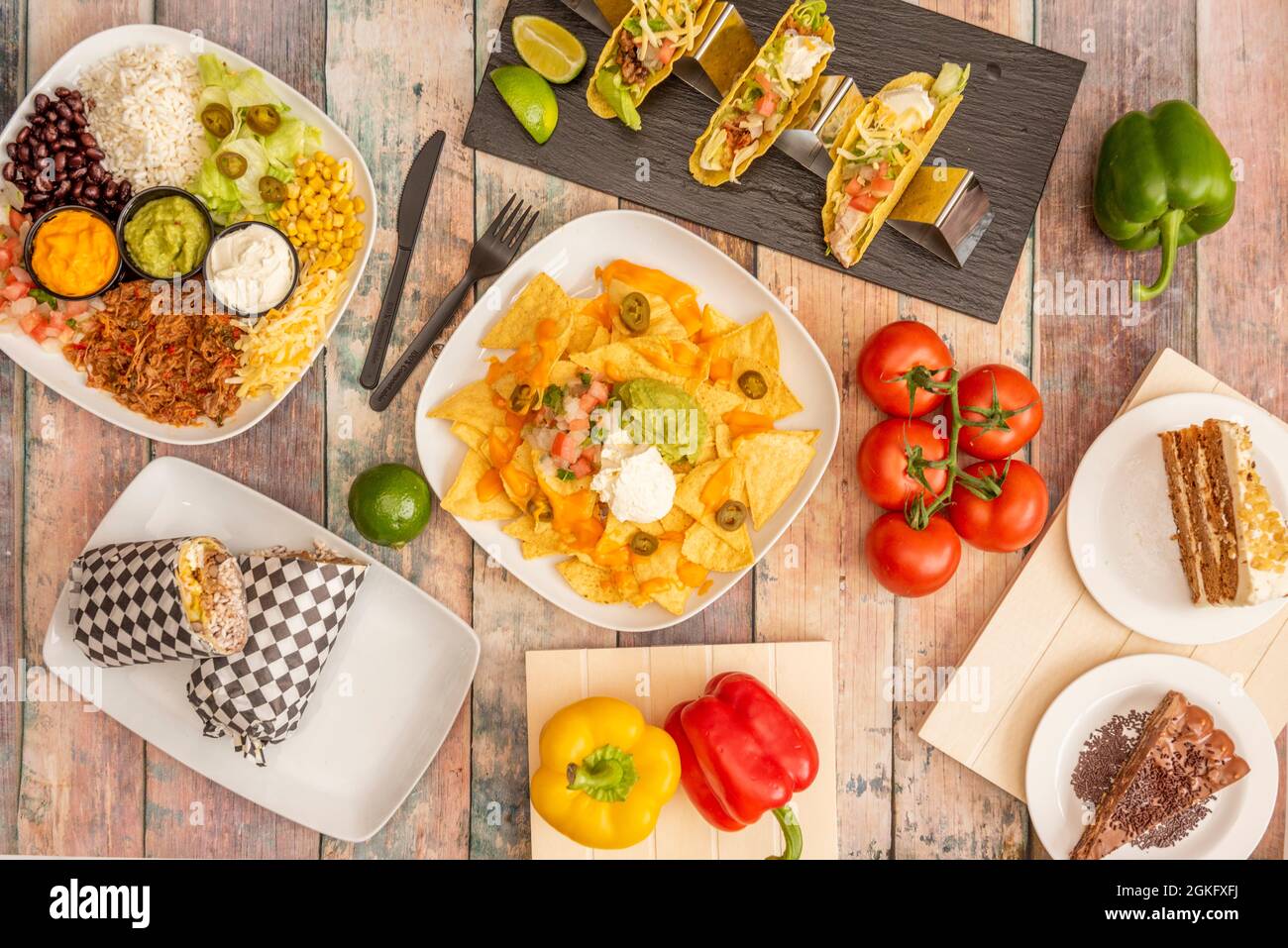 Set of colorful Mexican dishes with corn nachos, avocado guacamole, sweet corn, cheddar cheese, pico de gallo, crispy corn tacos, string tomatoes, ful Stock Photo