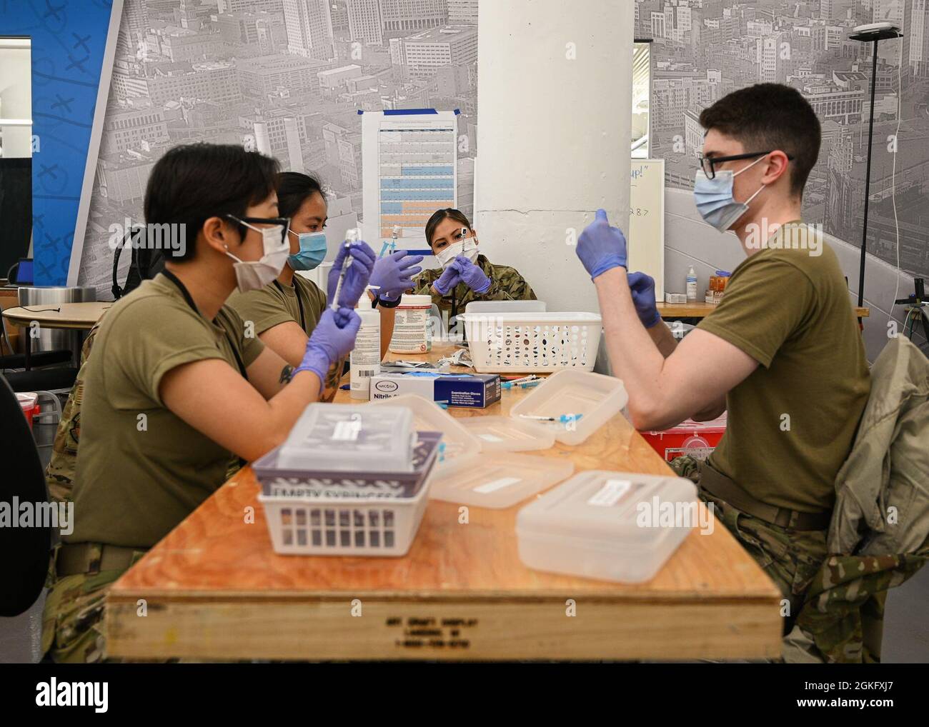 U.S. Airmen prepare doses of the COVID-19 vaccine at the state-run, federally-supported Ford Field Community Vaccination Center in Detroit, April 12, 2021. The Ford Field CVC is designed to vaccinate up to 6,000 community members per day. U.S. Northern Command, through U.S. Army North, remains committed to providing continued, flexible Department of Defense support to the Federal Emergency Management Agency as part of the whole-of-government response to COVID-19. Stock Photo