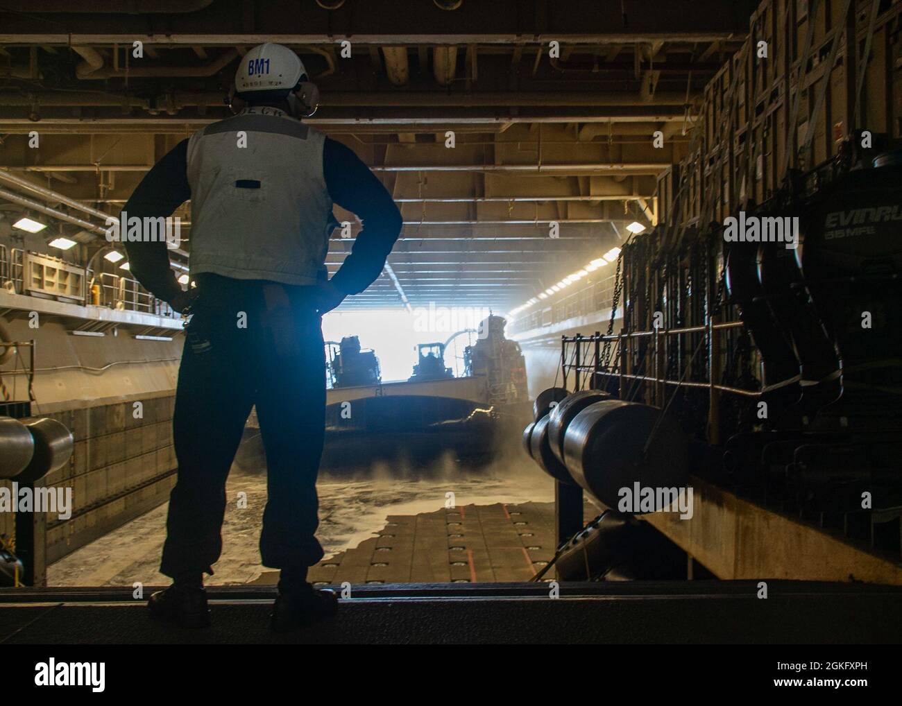 PACIFIC OCEAN (April 12, 2021) Boatswain’s Mate 1st Class Jeremiah Bennett, from Toledo, Ohio, observes as a landing craft, air cushion (LCAC), attached to Assault Craft Unit (ACU) 5, enters the well deck of the Wasp-class amphibious assault ship USS Essex (LHD 2). Essex is underway conducting routine operations in U.S. Third Fleet. Stock Photo