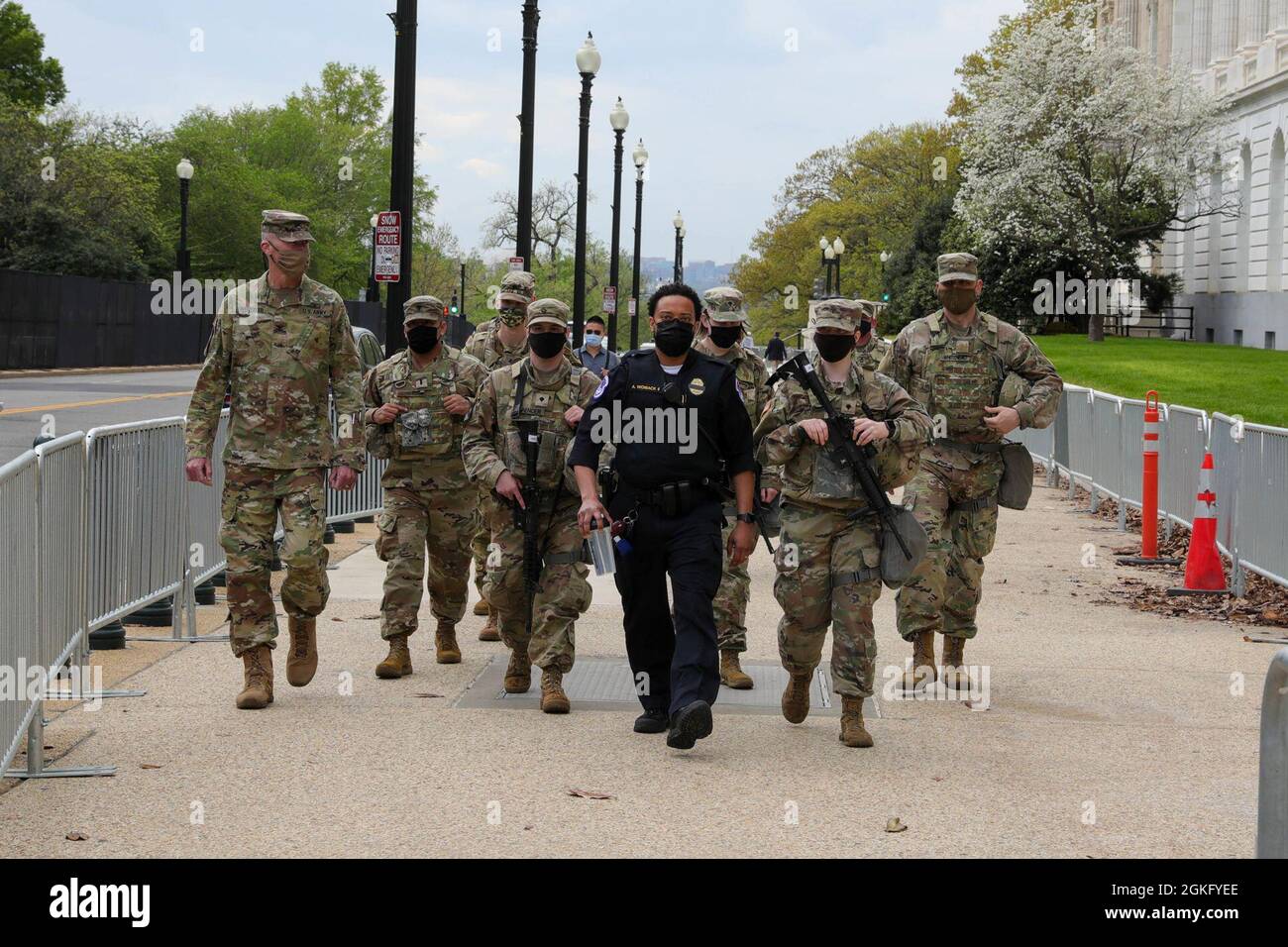 U.S. Capitol Police Officer Andre Womack II, center, patrols his area with his detail of Kentucky National Guard soldiers near the U.S. Capitol in Washington, D.C., April 12, 2021. The National Guard has been requested to continue supporting federal law enforcement agencies with security, communications, medical evacuation, logistics, and safety support to state, district and federal agencies through mid-May. Stock Photo