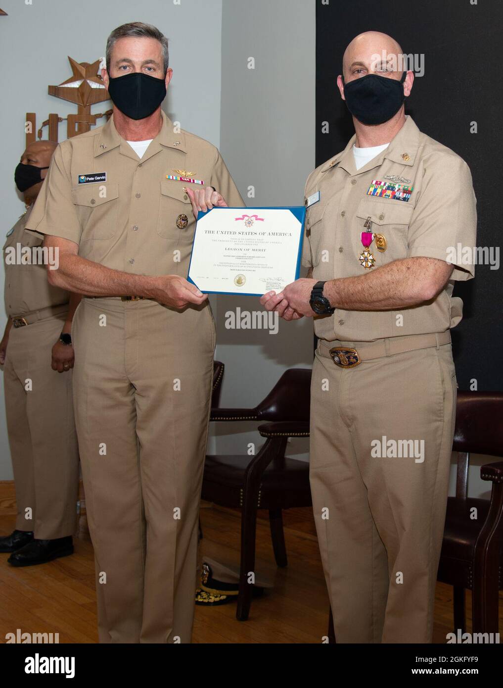 210412-N-EL867-0054 Newport, R.I. (April 12, 2021) Rear Adm. Pete Garvin, commander, Naval Education and Training Command, left, awards Command Master Chief Jason Avin, director, Senior Enlisted Academy (SEA), the Legion of Merit during the SEA change of charge ceremony, April 12. The ceremony also celebrated the expansion of Tomich Hall, the main classroom dedicated to senior enlisted leaders to improve management, leadership, national security and physical fitness. Tomich Hall will now be able to accommodate 218 students per class increasing the number of graduates from 1,232 to 2,398 a year Stock Photo