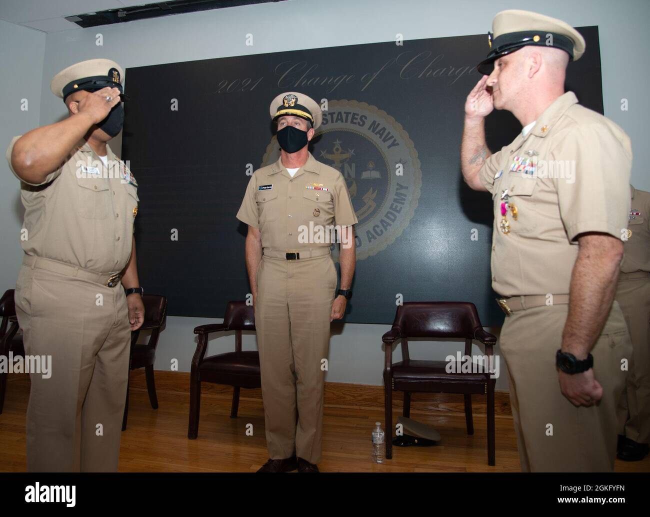 210412-N-EL867-0067 Newport, R.I. (April 12, 2021) Rear Adm. Pete Garvin, commander, Naval Education and Training Command (center), presides as Command Master Chief Jason Avin, right, is properly relieved by Command Master Chief Baron Randle, as the Senior Enlisted Academy director during their change of charge ceremony, April 12. The ceremony also celebrated the expansion of Tomich Hall, the main classroom dedicated to senior enlisted leaders to improve management, leadership, national security and physical fitness. Tomich Hall will now be able to accommodate 218 students per class increasing Stock Photo
