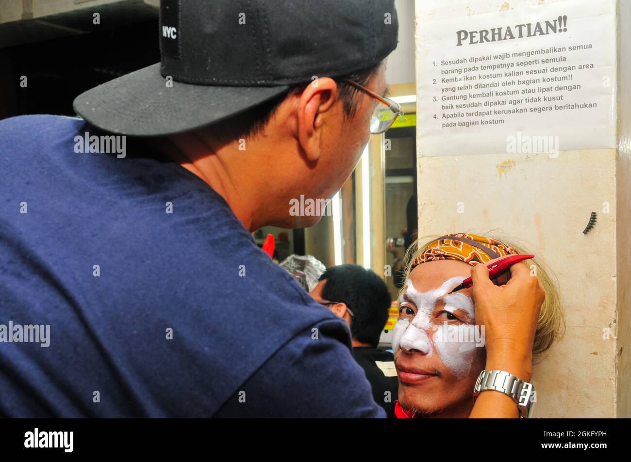 A make-up artist is doing makeup for a dancer who will appear on the stage. Stock Photo