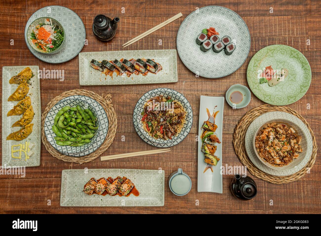 set of japanese and asian food dishes. Red tuna makis, yakisoba noodles, gyozas, edamame, udon