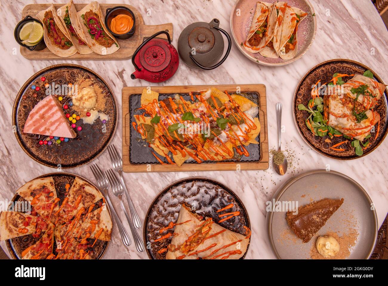 Set of delicious dishes of popular Mexican food, nachos with guacamole, cochinita tacos, full burrito, synchronized quesadillas, tacos al pastor Stock Photo