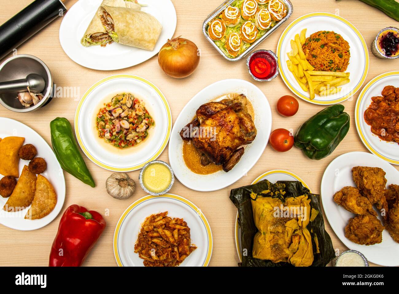 Top view image of set of dishes with recipes of European and Latin food on wooden table, tamales, empanadas, salpicon, roast chicken, burritos, Italia Stock Photo