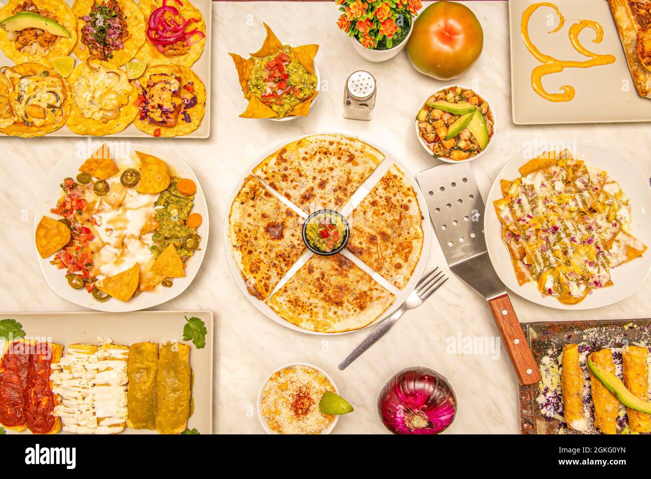 Set of popular Mexican dishes. Synchronized quesadillas, nachos with guacamole, golden tacos, assorted tacos, aguacate, guacamole, corn chips, purple Stock Photo