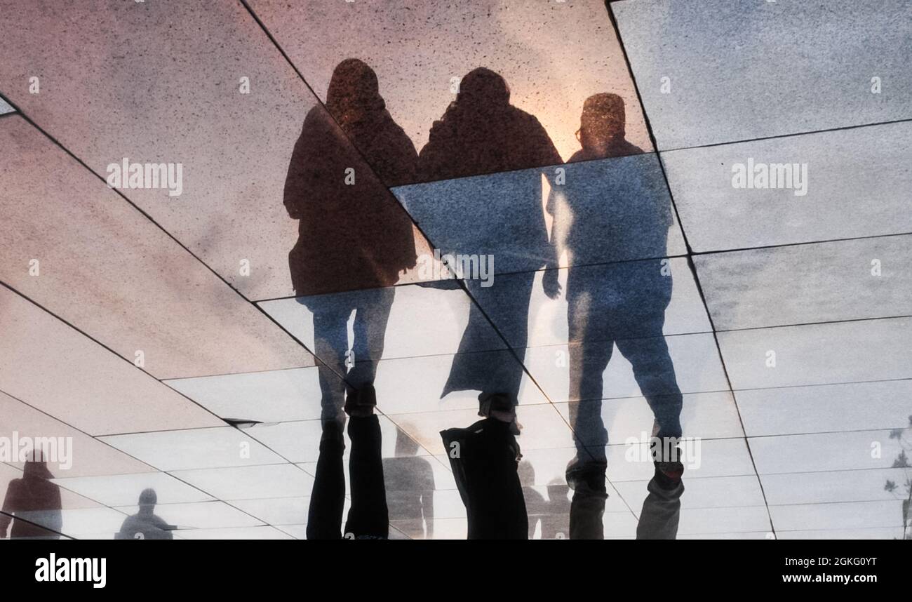 Reflecting shadows of people walking on the floor, reversed photo. Stock Photo