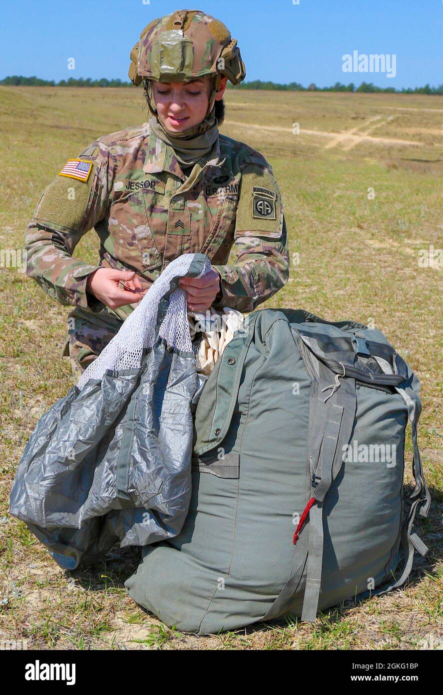 A Paratrooper from the 82nd Airborne Division packs her T-11 parachute into  her Universal Parachutist Recovery Bag on the Sicily Drop Zone after a  Women's Equality Jump at Fort Bragg, N.C., April