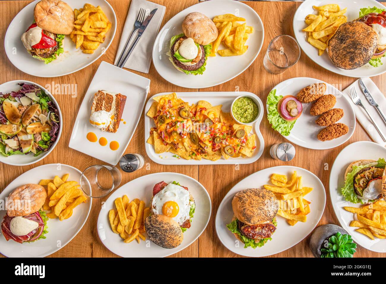 Set of plates of tex-mex food and hamburgers and appetizers on wooden table Stock Photo