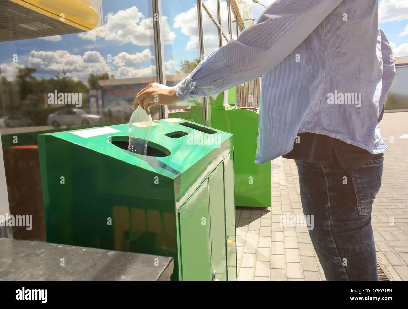 Woman throwing plastic bottle into litter bin outdoors Stock Photo Alamy