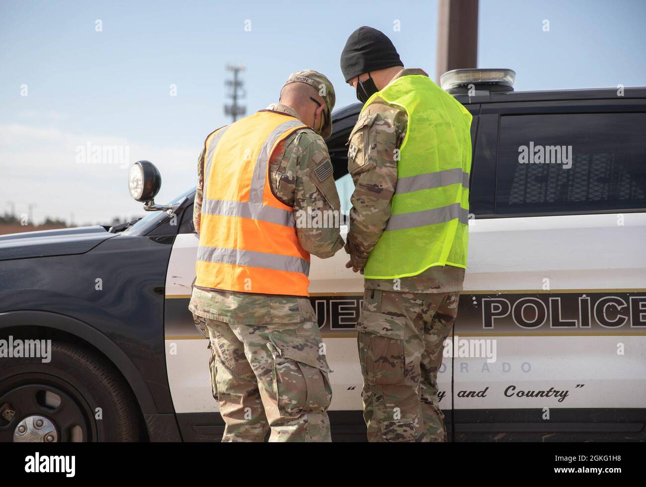 U.S. Army Staff Sgt. Joshua Waldron, left, and Cpl. Elijah Miles, right, cavalry scouts assigned to 3rd Squadron, 61st Cavalry Regiment, screen a Pueblo police officer prior to receiving a vaccination at the Pueblo Community Vaccination Center at the Colorado State Fairgrounds in Pueblo, Colorado, April 14, 2021. The Soldiers deployed from Fort Carson, Colorado to administer vaccinations to members of the Pueblo community. U.S. Northern Command, through U.S. Army North, remains committed to providing continued, flexible Department of Defense support to the Federal Emergency Management Agency a Stock Photo
