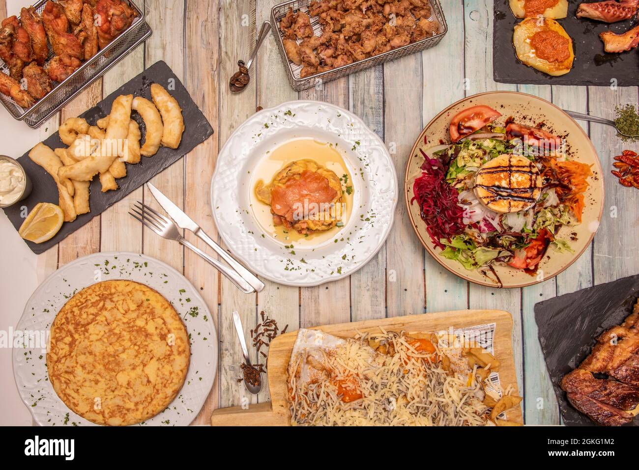 Tapas dishes and Spanish food. Entrecote, goat salad, croquettes, wings