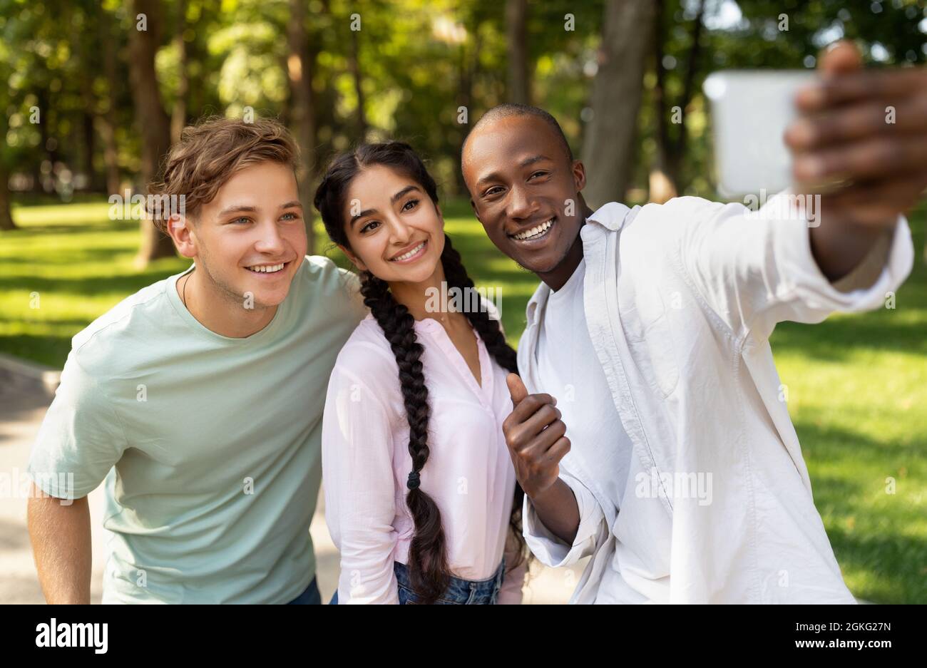 Capturing moments. Cheerful african american student guy taking selfie with his university friends in campus Stock Photo
