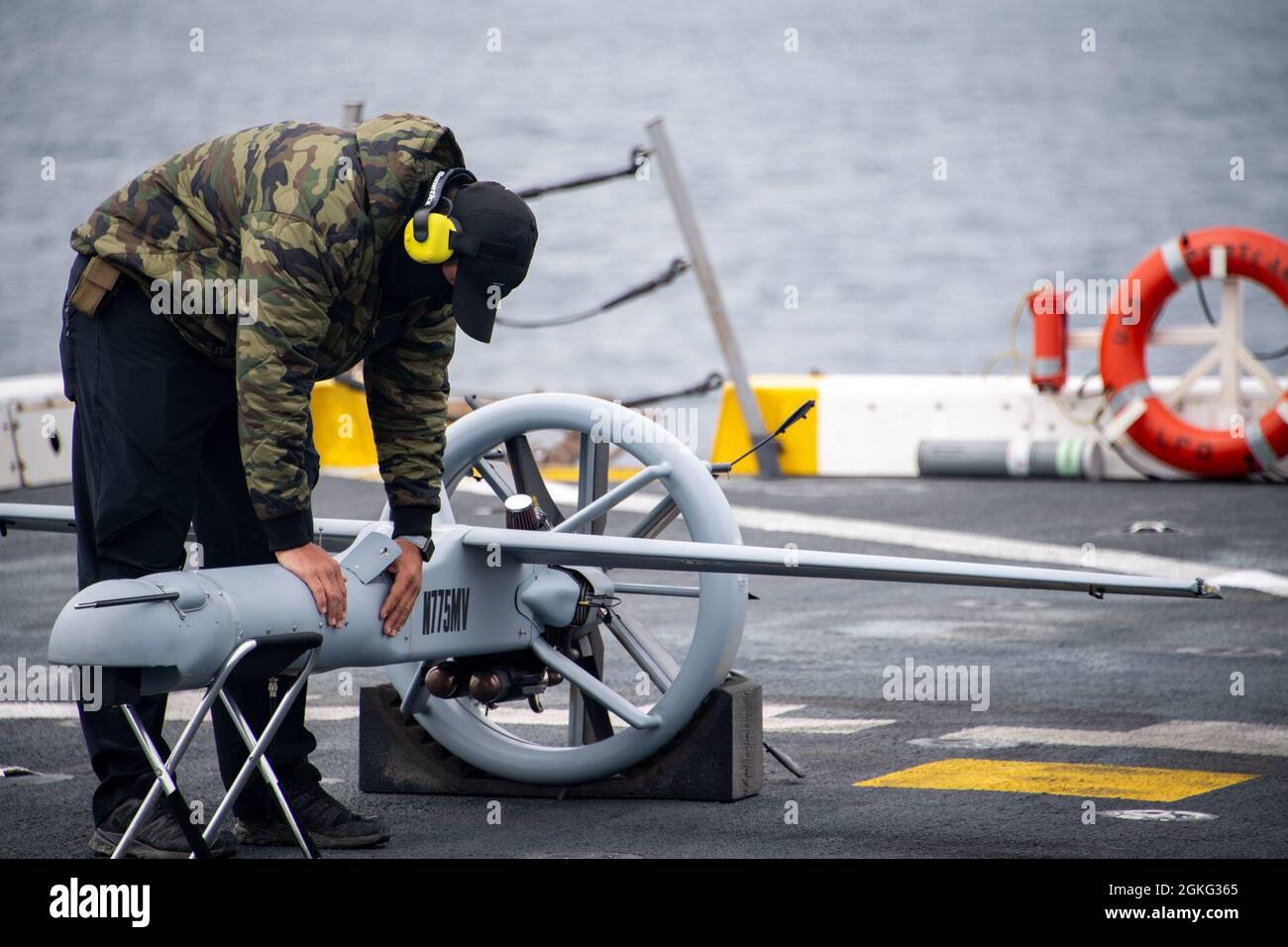 PACIFIC OCEAN (April 13, 2021) — Joshua Fasnacht, a representative from Martin UAV, checks the internals of a V-Bat vertical take-off and landing unmanned aerial vehicle on the flight deck of amphibious transport dock USS Portland (LPD 27), April 13. Portland is underway conducting routine operations in U.S. Third Fleet. Stock Photo