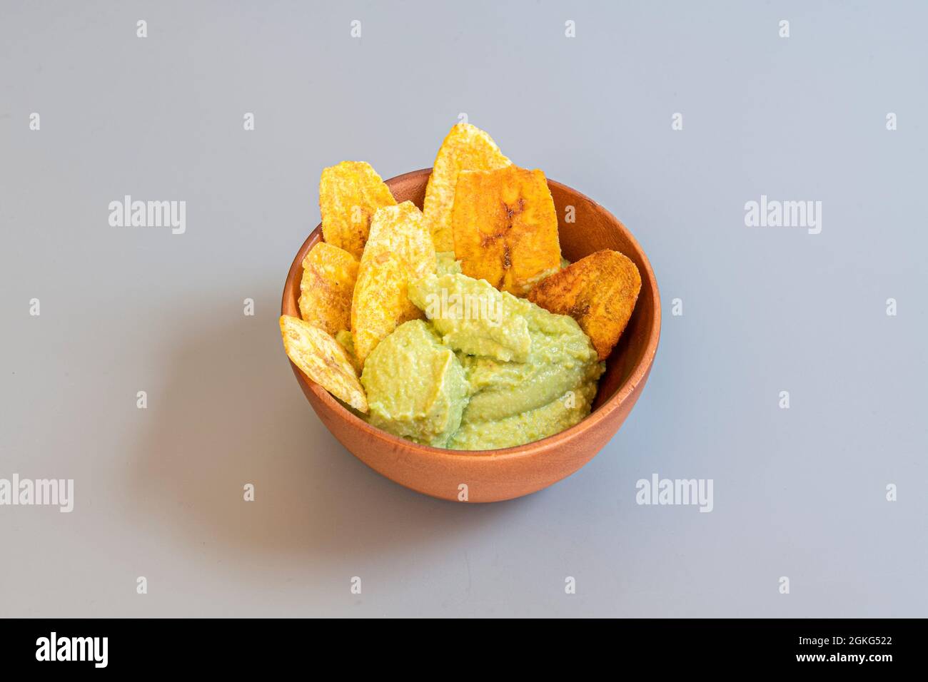 Wooden bowl with new recipe for edamame hummus with plantain chips