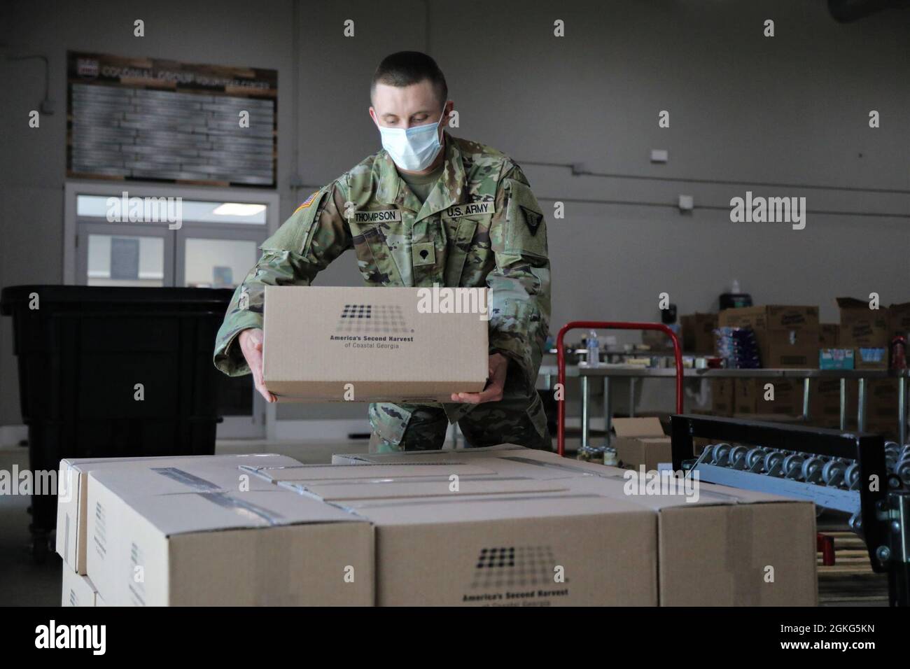 U.S. Army Spc. Jacob Thompson, a plumber with the Fort Stewart-based Land Dominance Center, 78th Troop Command, Georgia Army National Guard stacks a box of food April 14, 2021, at America’s Second Harvest of Coastal Georgia food bank in Savannah, Georgia. Georgia Guardsmen provided support to food banks across the state to help citizens in need during the COVID-19 pandemic. Stock Photo