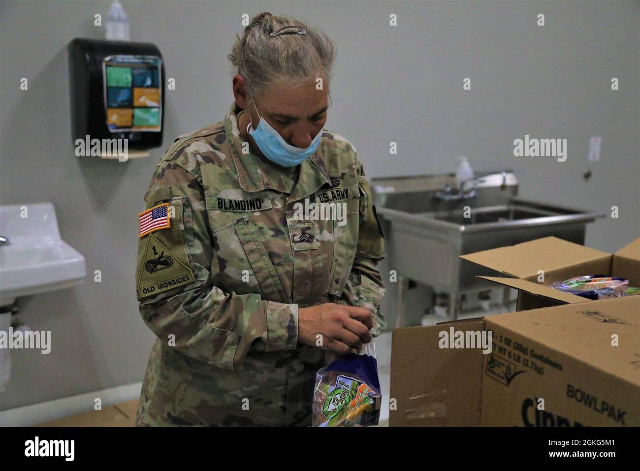 U.S. Army Sgt. Mary Blandino, an automated logistical specialist with the Fort Stewart-based Land Dominance Center, 78th Troop Command, Georgia Army National Guard packs a box of food April 14, 2021, at America’s Second Harvest of Coastal Georgia food bank in Savannah, Georgia. Georgia Guardsmen provided support to food banks across the state to help citizens in need during the COVID-19 pandemic. Stock Photo