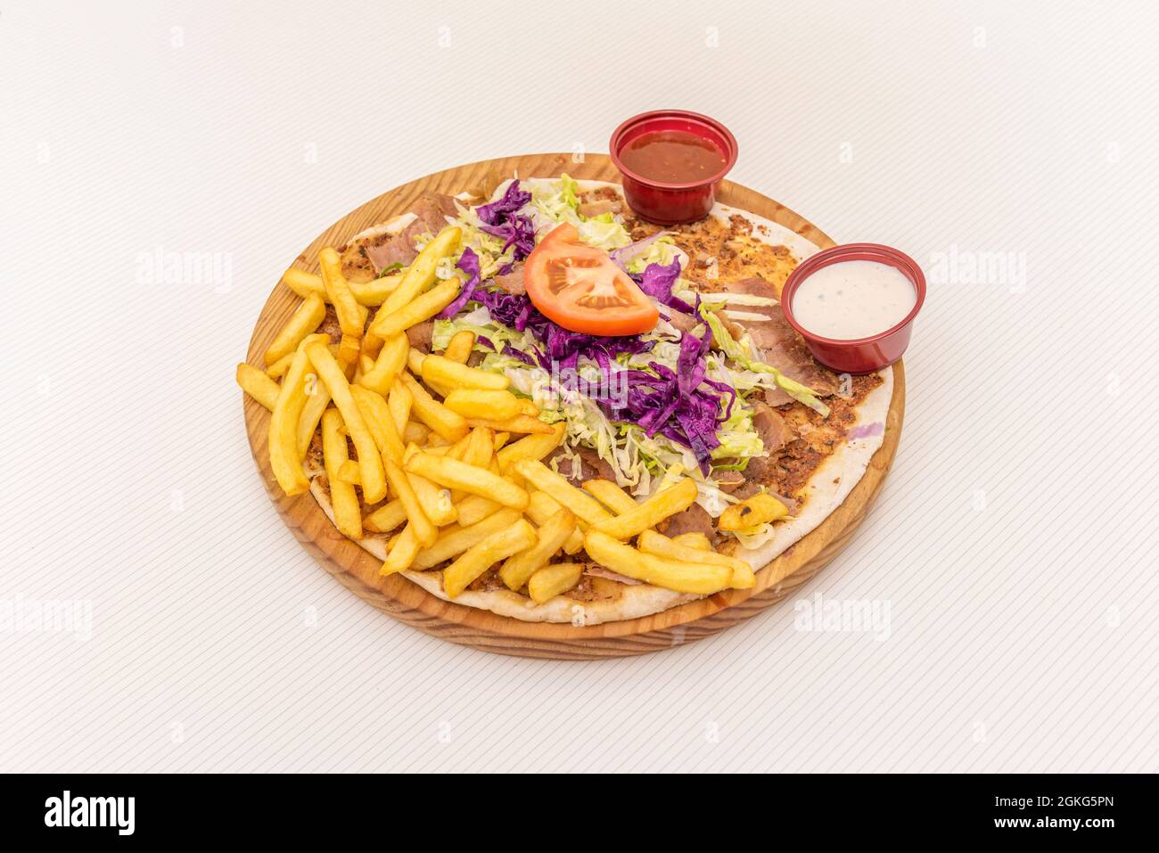 Turkish lahmacun pizza with purple cabbage, iceberg lettuce, tomato and lamb fries. Stock Photo