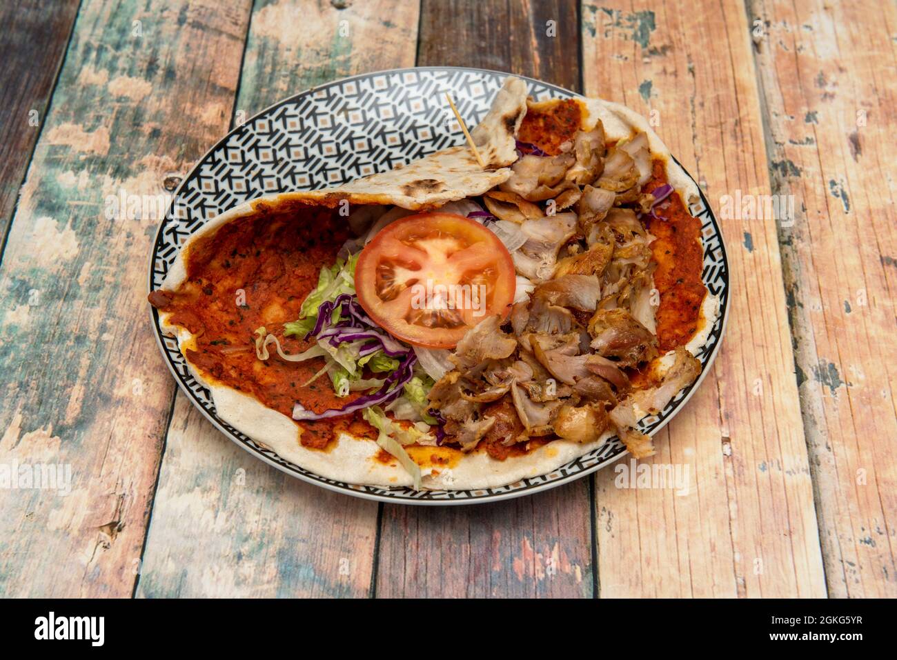 Lahmacun cooked by Arab chef with lamb kebab meat, tomato slice, white onion, purple kale on nice plate Stock Photo