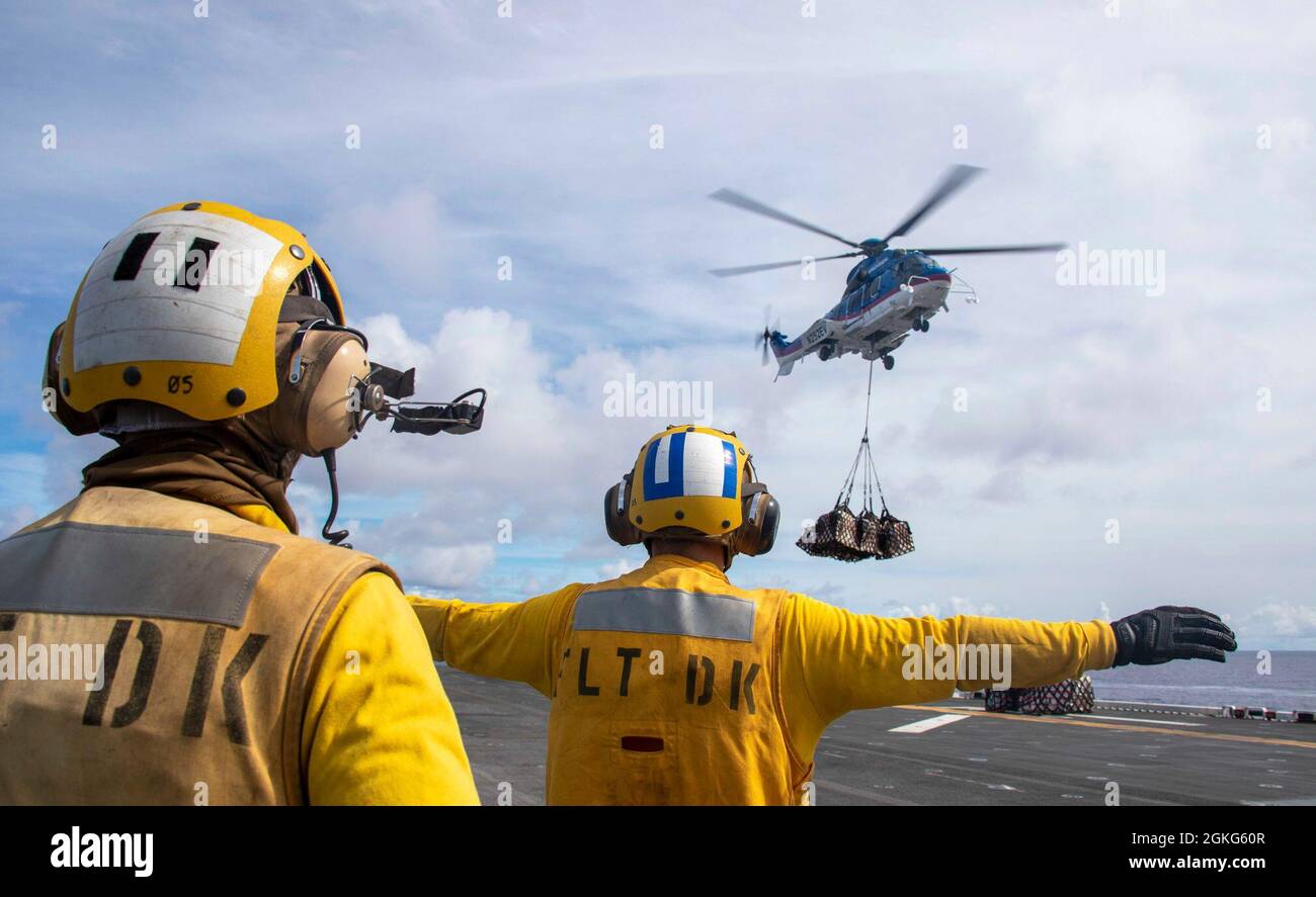 210414-N-LD903-1227 PACIFIC OCEAN (April 14, 2021) – U.S. Navy Aviation  Boatswain's Mate (Handling) Matthew Carson, left, and Airman Sean Opalka  direct an Airbus H225 Super Puma helicopter aboard the amphibious assault  ship