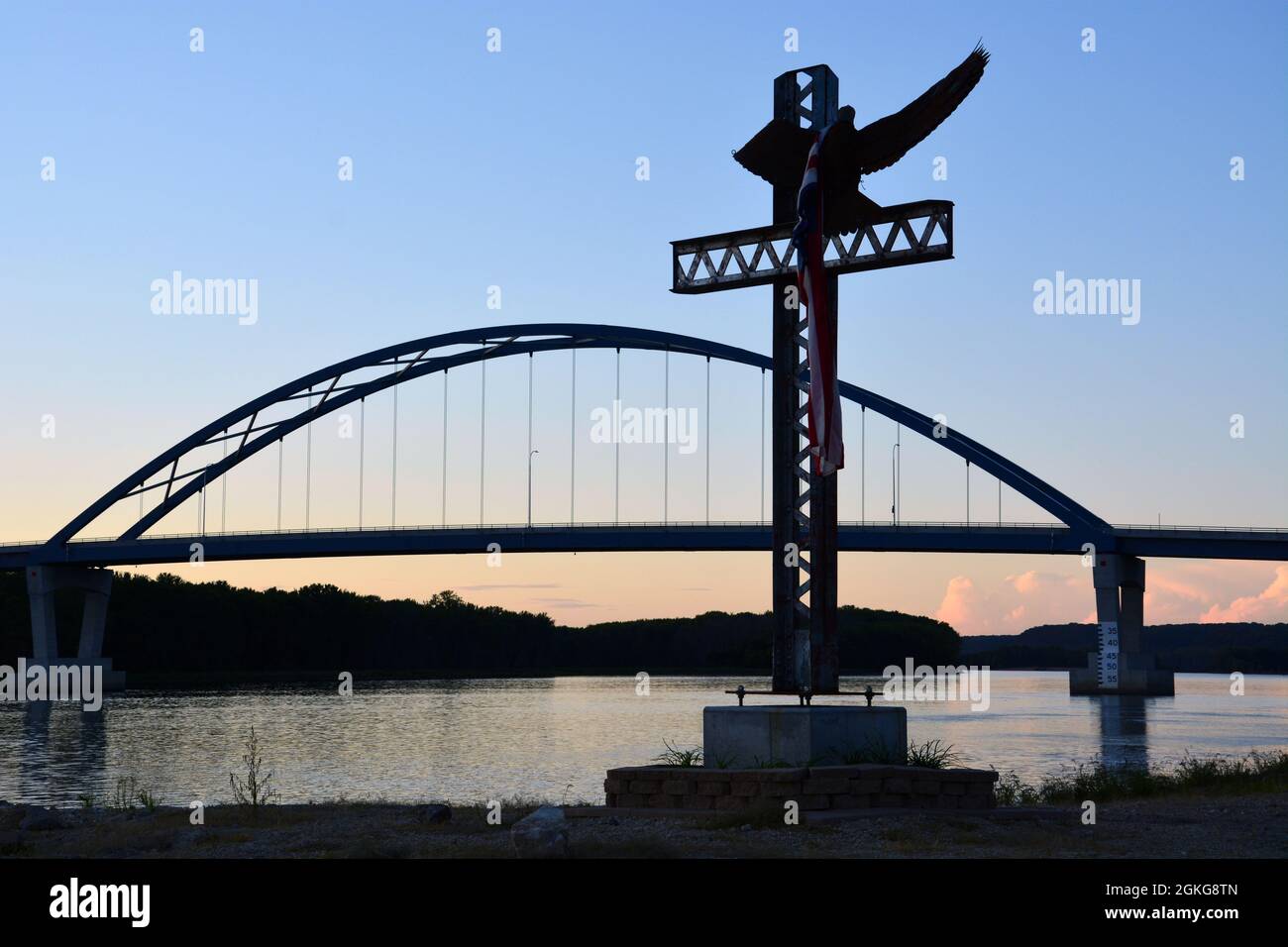 The 'River Eagle' sculpture at sunset on the Mississippi River in Savanna, IL, with the US 52 bridge in the background. Stock Photo