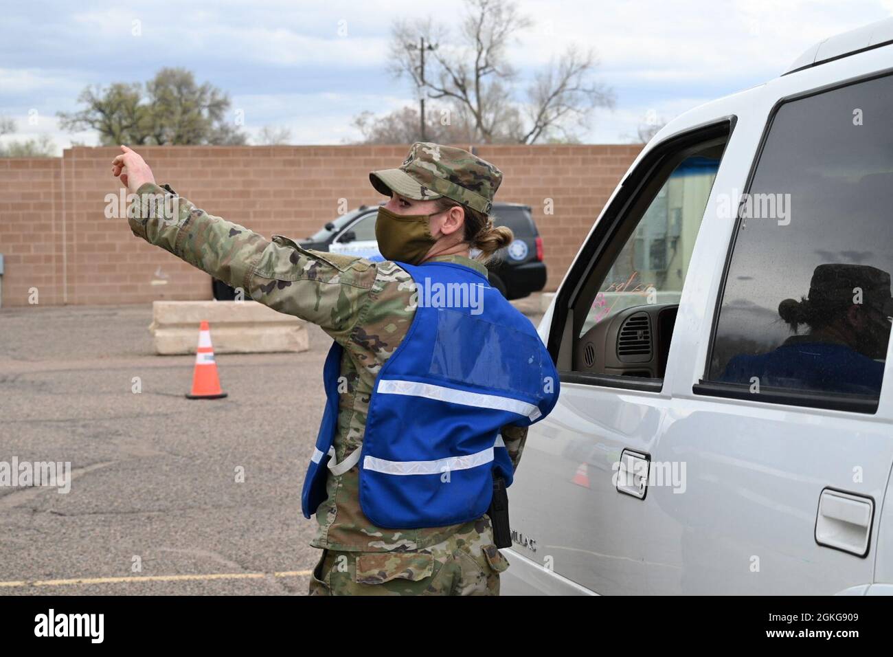 U.S. Army Staff Sgt. Teri Chojnacki, a Cross City, Florida native and combat medic, assigned to 1st Battalion, 41st Infantry, directs a vehicle at the drive-up lanes at the Community Vaccination Center in Pueblo, Colorado, April 15, 2021. The drive-up lanes enable community members to acquire their COVID vaccination without having to exit their vehicles. U.S. Northern Command, through U.S. Army North, remains committed to providing continued, flexible Department of Defense support to the Federal Emergency Management Agency as part of the whole-of-government response to COVID-19. Stock Photo