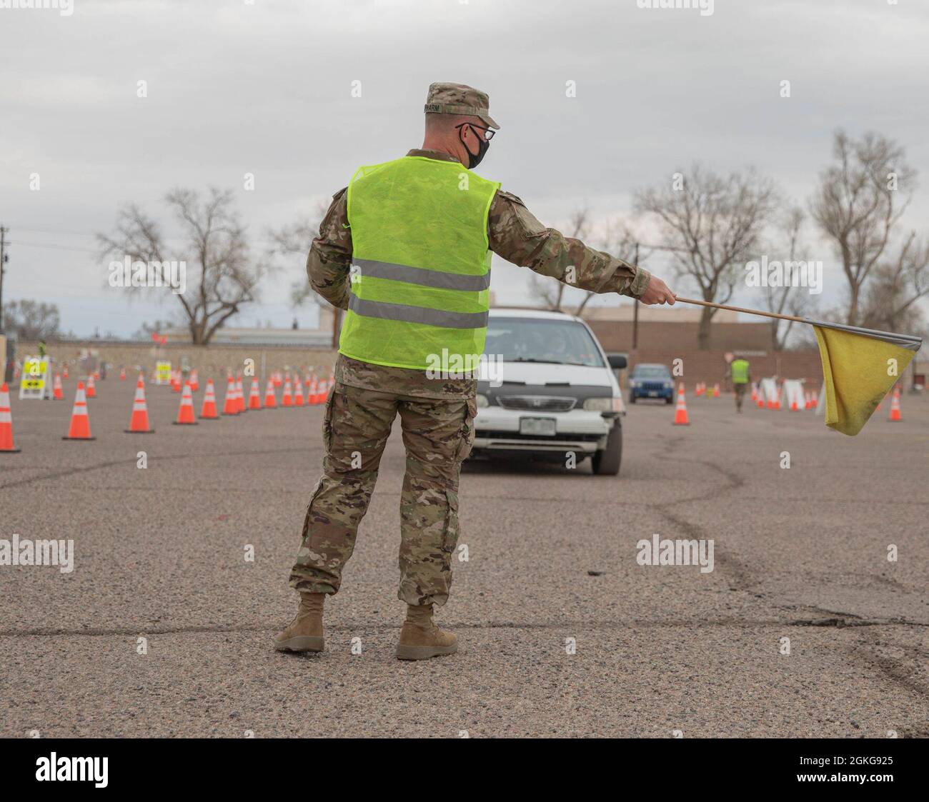 U.S. Army Pvt. Bradley Schwarm, a cavalry scout assigned to 3rd Squadron, 61st Cavalry Regiment, directs a community member to a vaccination lane in Pueblo, Colorado, April 15, 2021. The Soldiers deployed from Fort Carson, Colorado, to administer vaccinations to members of the Pueblo community. U.S. Northern Command, through U.S. Army North, remains committed to providing continued, flexible Department of Defense support to the Federal Emergency Management Agency as part of the whole-of-government response to COVID-19. Stock Photo