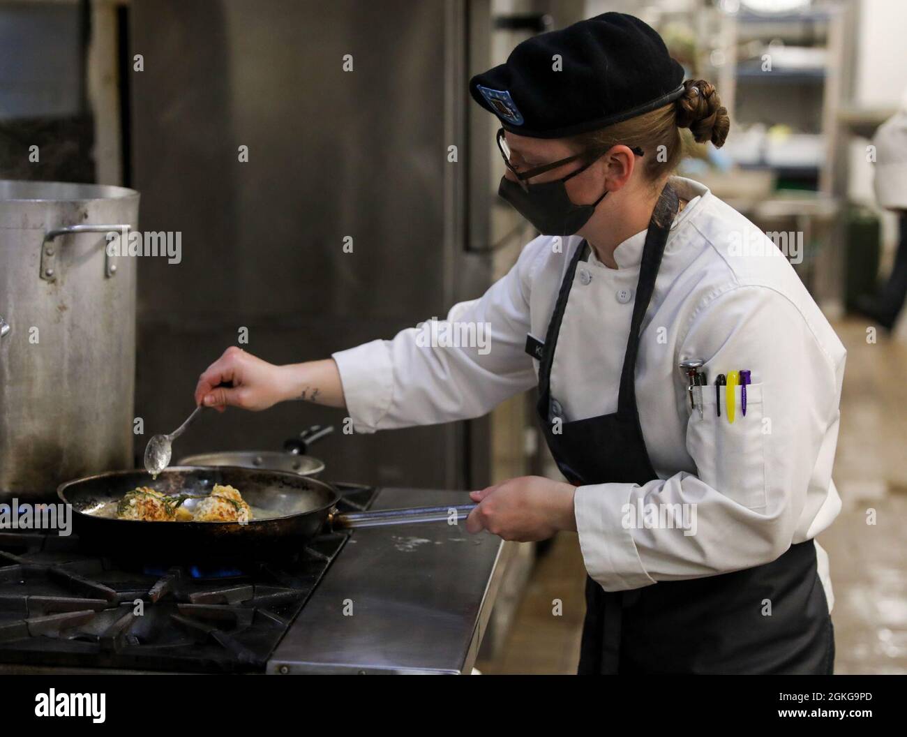 Sgt. Danielle Klein, a culinary specialist with Foxtrot Battery, 2nd Battalion, 15th Field Artillery Regiment, 2nd Brigade Combat Team, 10th Mountain Division (LI) bastes her entree in butter for a cook-off during the 2nd BCT Chef of the Quarter Board on April 15th, 2021, at Fort Drum, N.Y. Chef of the Quarter Boards highlight the sharpest chefs in dining facilities across the U.S. Army. Stock Photo