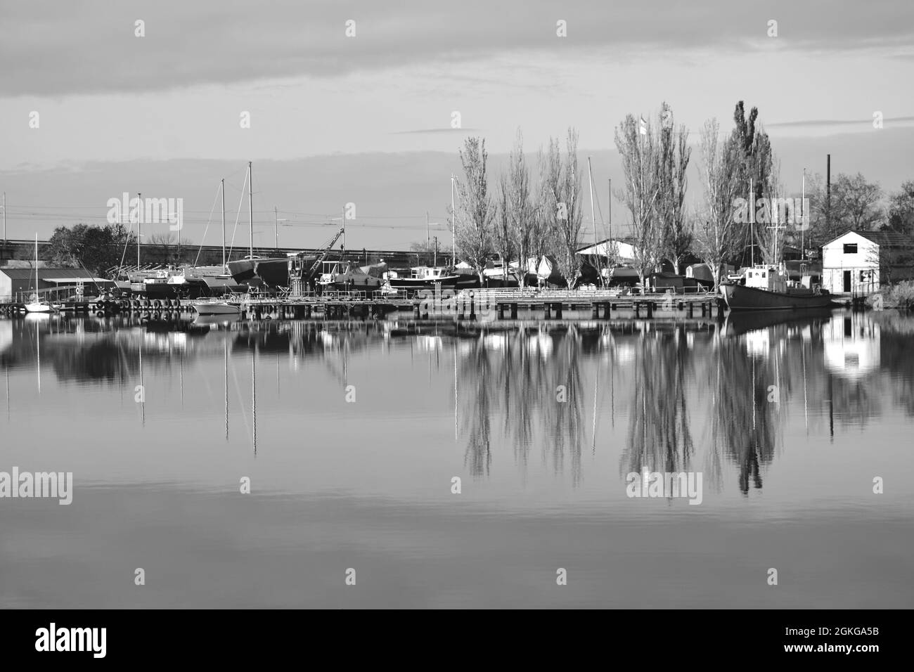 Black and white picture. Autumn reflections at river.Beautiful landscape with trees and boats at the river Stock Photo