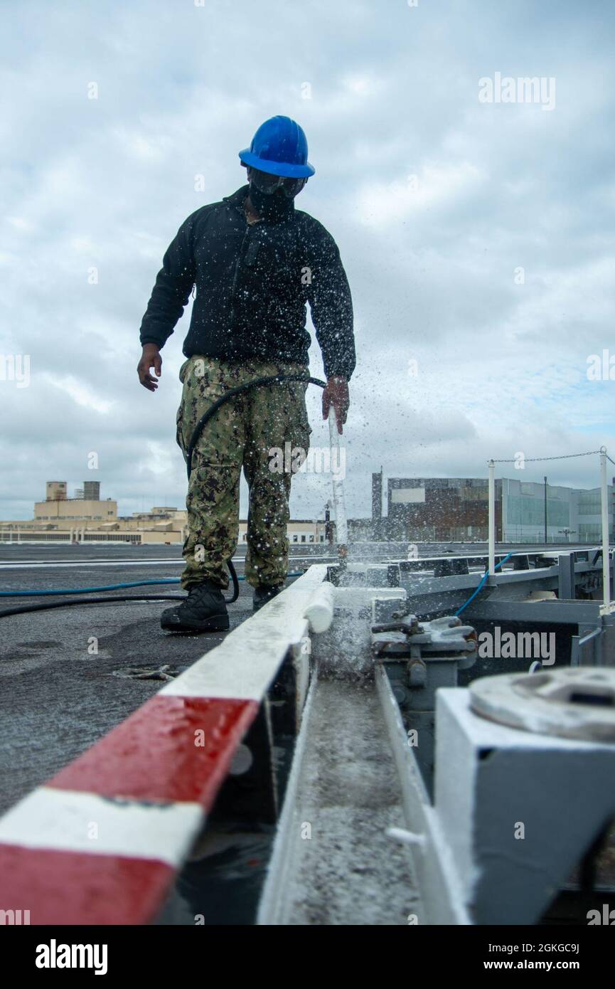 210415-N-NV669-1123 PORTSMOUTH, Va. (April 15, 2021) Airman Jaquame Russell, from Miami, uses a blowdown hose to clean the guard rail on the flight deck of the Nimitz-class aircraft carrier USS Harry S. Truman (CVN 75). Truman is currently in Norfolk Naval Shipyard for its Extended Carrier Incremental Availability (ECIA) period. Stock Photo