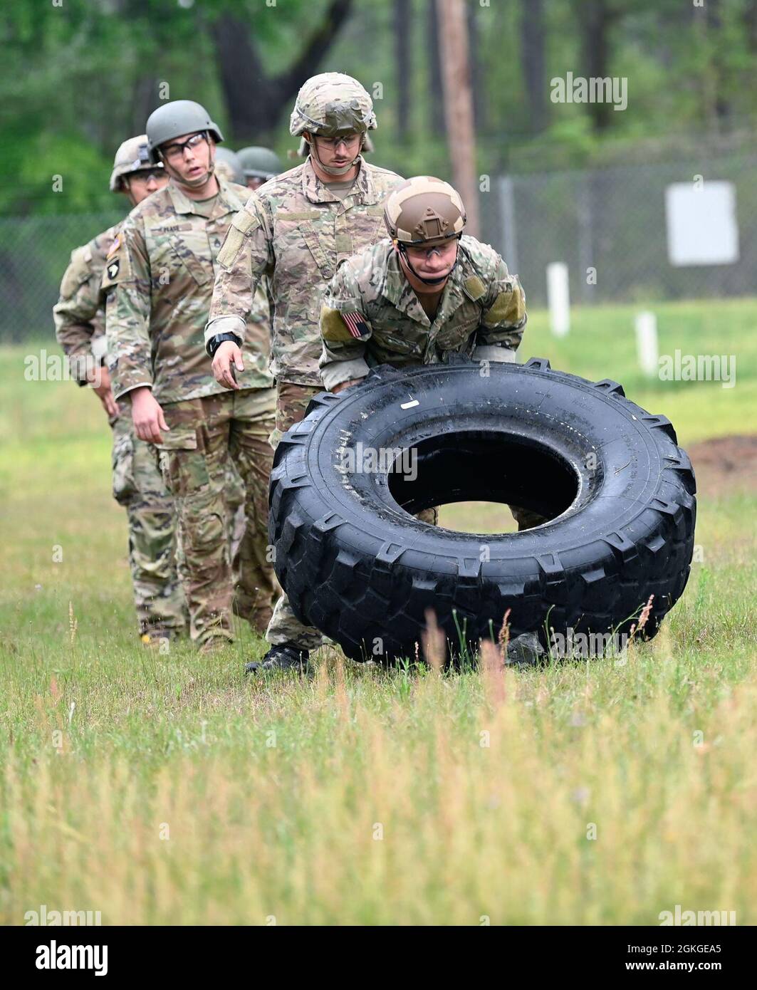 A Soldier from Support Battalion, 1st Special Warfare Training Group (Airborne) flips a truck tire as part of a stress-shoot during the battalion's Commander's Cup competition at Fort Bragg, North Carolina April 15, 2021. The Soldiers from each company competed in a ruck march, obstacle course, land navigation, Jeopardy-themed trivia contest and stress shoot with pistols and rifles. Stock Photo