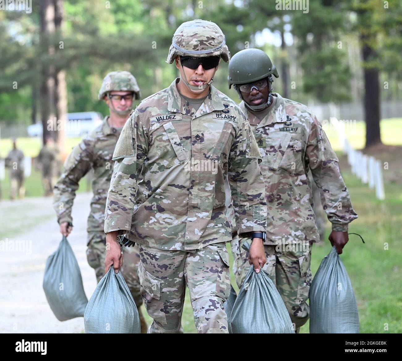 Soldiers from Support Battalion, 1st Special Warfare Training Group (Airborne) carry sandbags as part of a stress-shoot during the battalion's Commander's Cup competition at Fort Bragg, North Carolina April 15, 2021. The Soldiers from each company competed in a ruck march, obstacle course, land navigation, Jeopardy-themed trivia contest and stress shoot with pistols and rifles. Stock Photo