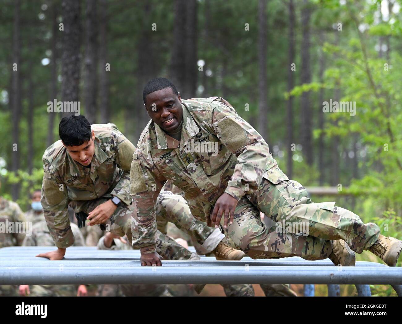 Soldiers from Support Battalion, 1st Special Warfare Training Group (Airborne) negotiate an obstacle during the battalion's Commander's Cup competition at Fort Bragg, North Carolina April 15, 2021. The Soldiers from each company competed in a ruck march, obstacle course, land navigation, Jeopardy-themed trivia contest and stress shoot with pistols and rifles. Stock Photo