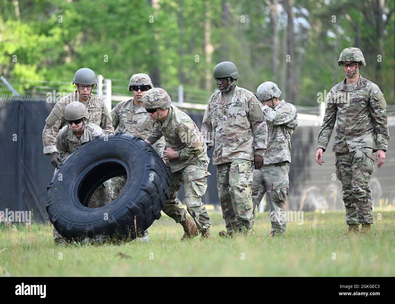 Soldiers from Support Battalion, 1st Special Warfare Training Group (Airborne) flip a truck tire as part of a stress-shoot during the battalion's Commander's Cup competition at Fort Bragg, North Carolina April 15, 2021. The Soldiers from each company competed in a ruck march, obstacle course, land navigation, Jeopardy-themed trivia contest and stress shoot with pistols and rifles. Stock Photo