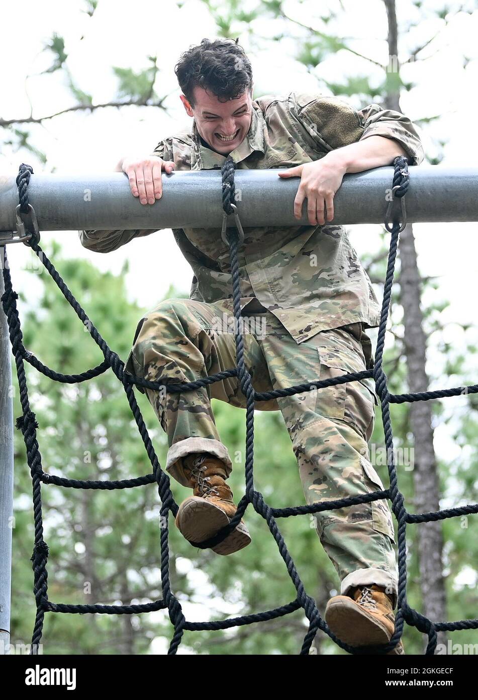 A Soldier from Support Battalion, 1st Special Warfare Training Group (Airborne) climbs a cargo net during the battalion's Commander's Cup competition at Fort Bragg, North Carolina April 15, 2021. The Soldiers from each company competed in a ruck march, obstacle course, land navigation, Jeopardy-themed trivia contest and stress shoot with pistols and rifles. Stock Photo