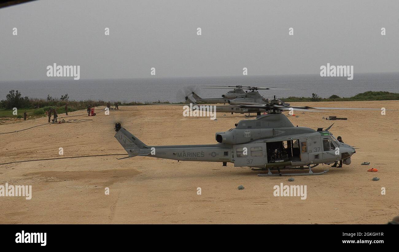 A U.S. Marine Corps UH-1Y Venom and AH-1Z Viper helicopters assigned to Marine Light Attack Helicopter Squadron (HMLA) 267 land at a forward arming and refueling point during a mission rehearsal exercise (MRX) at Ie Shima training facility, Okinawa, Japan, April 16, 2021. The MRX served as a culminating event for HMLA-267 as they near the end of their time in Okinawa as part of the Unit Deployment Program. Stock Photo