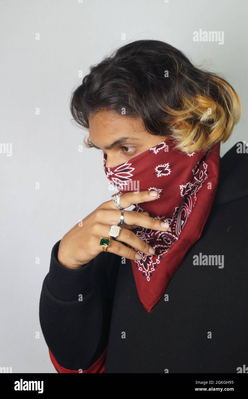 Young thug Indian male with a bandana covering his face and rings on his fingers Stock Photo Alamy