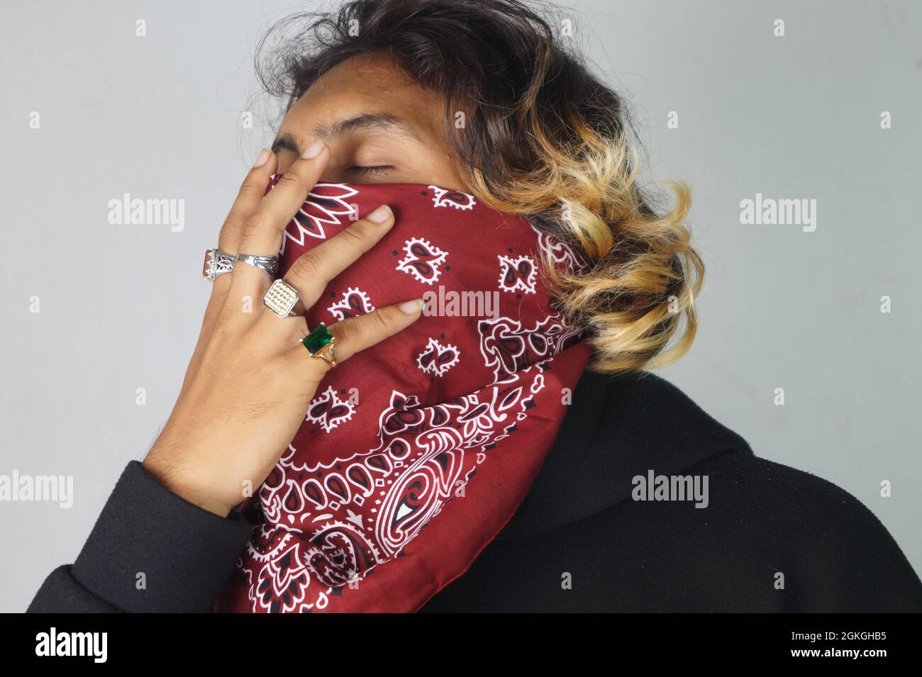 Young thug Indian male with a bandana covering his face and rings on his fingers Stock Photo Alamy