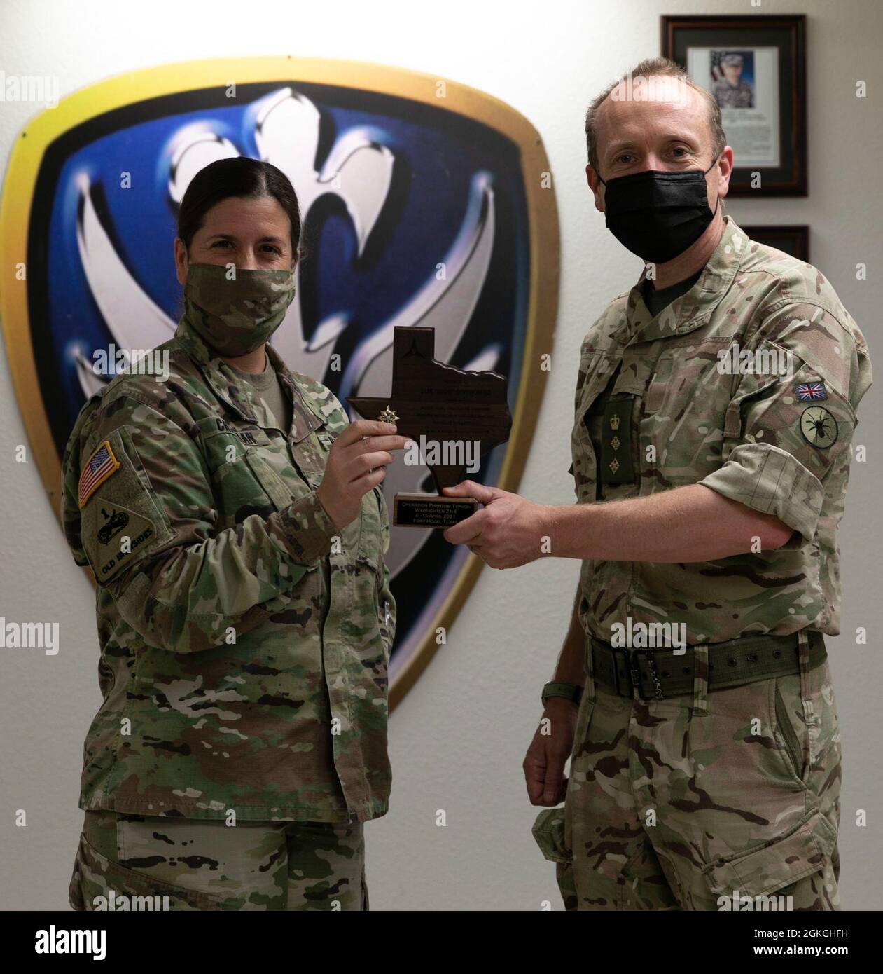 Col. Jennifer Chapman, III Armored Corps Intelligence Officer, gives a token of appreciation to Col. Nathaniel Haden, 1st Intelligence Surveillance and Reconnaissance Brigade, 3rd U.K. Division at Fort Hood, Texas, April 16, 2021. Stock Photo