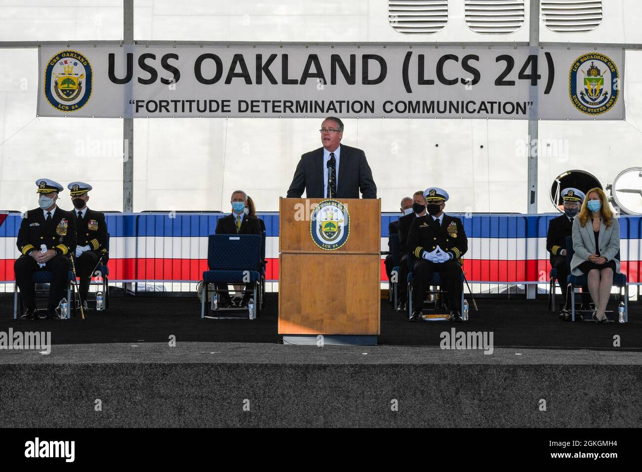 210417-N-YS140-105  Oakland, Calif. (April 17, 2021) Acting Secretary of the Navy Thomas W. Harker provides the principal address during the commissioning ceremony of USS Oakland (LCS 24). The LCS is a fast, agile, mission-focused platform designed to operate in near-shore environments, while capable of open ocean tasking. The LCS can support forward presence, maritime security, sea control, and deterrence. Oakland will be homeported San Diego. Stock Photo